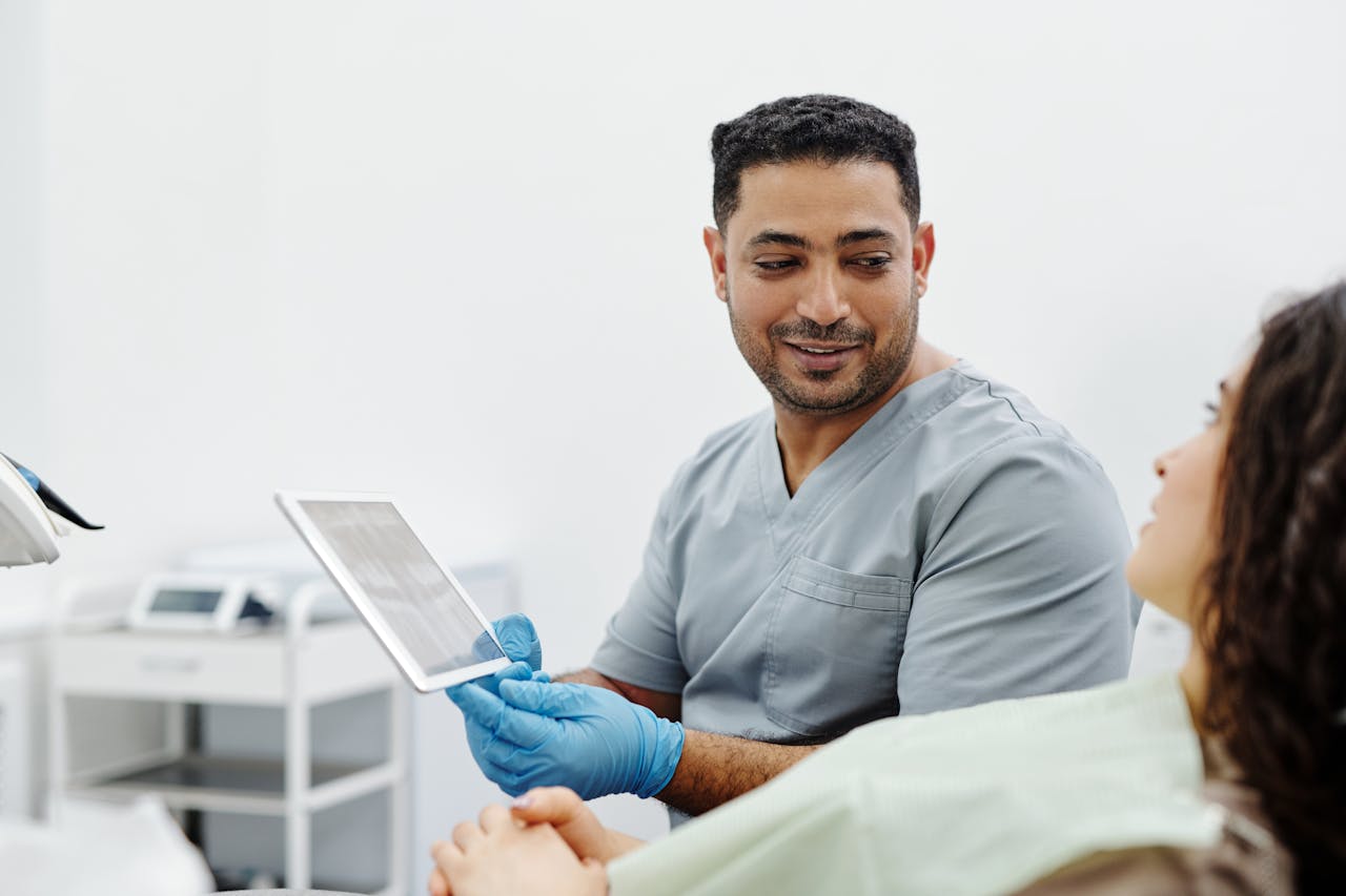 our-mission Nurse uses digital tablet for patient consultation and diagnosis in a clinical setting.