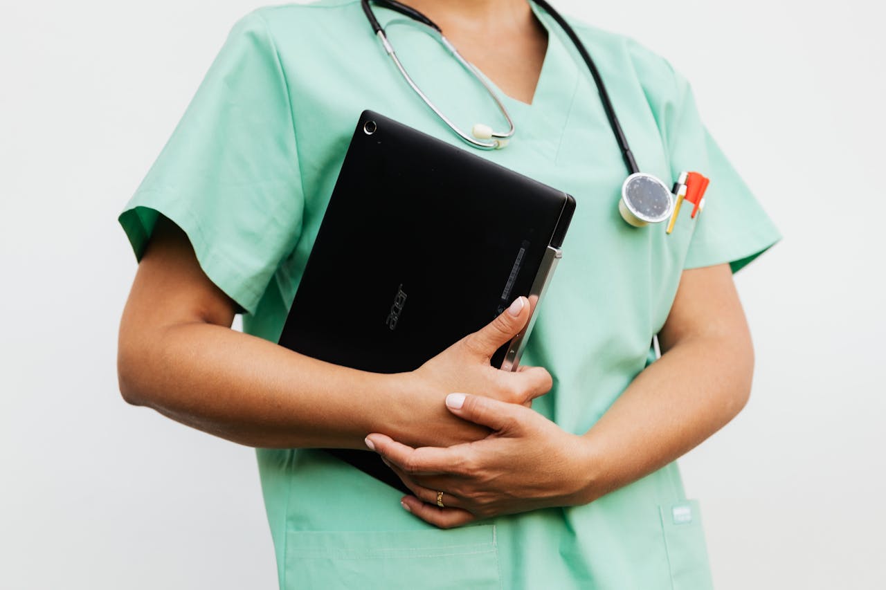 portfolio-04 Close-up of a nurse in green scrubs holding a tablet and stethoscope, symbolizing modern healthcare.