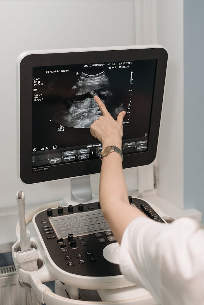 why-choose-us A medical professional analyzing an ultrasound image on a monitor in a clinical setting.